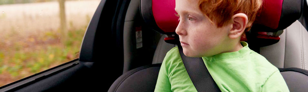 Image of a boy buckled in back seat of car
