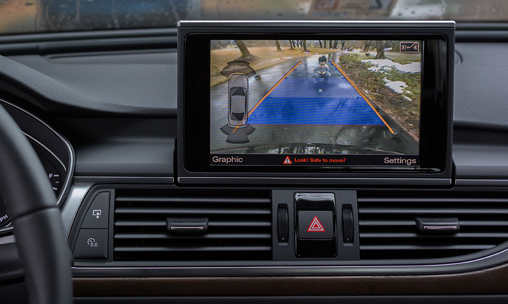 Rearview camera showing child in driveway behind car